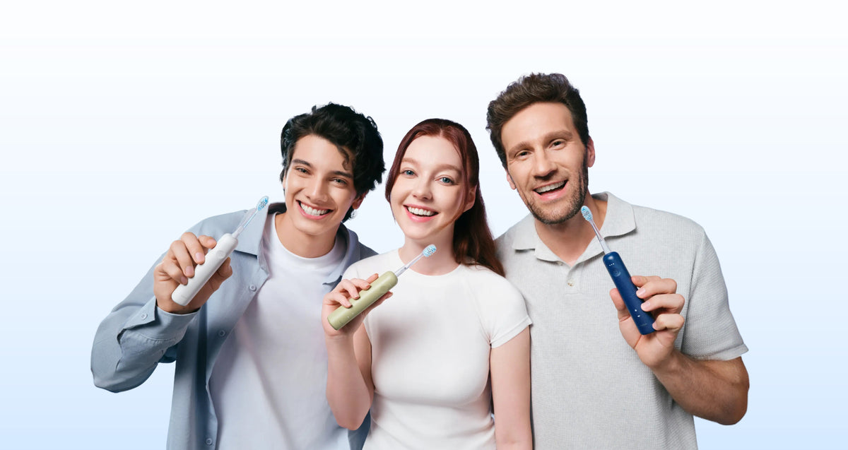 Three people holding Wave Lite toothbrushes